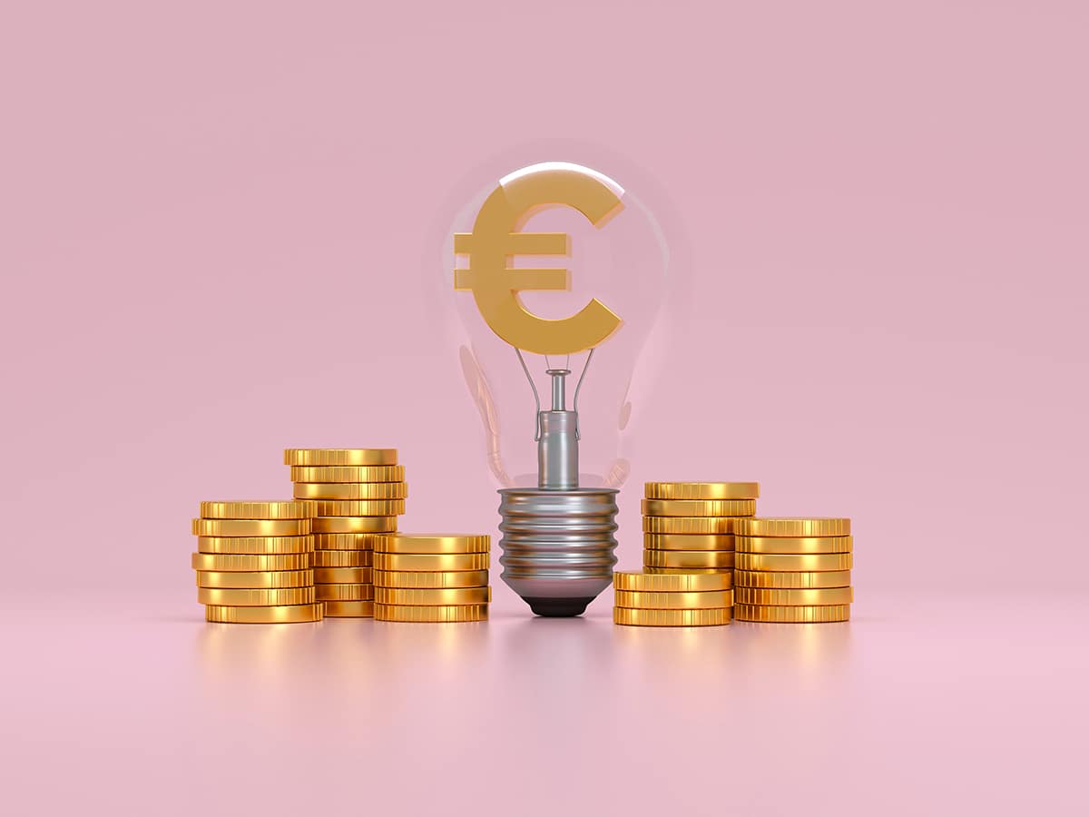6 piles de monnaies sur un fond rose avec au centre une ampoule électrique avec logo Euro dorée au centre