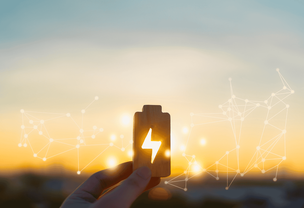 Une main tient une pile en premier plan. Au fond on aperçoit en filigrane un réseau interconnecté sur fond de soleil couchant.