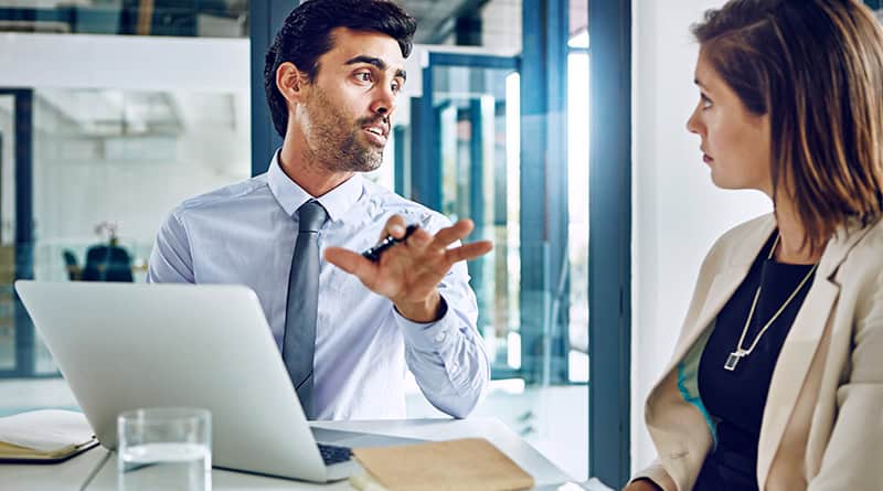 un homme avec son ordinateur dialogue avec une femme