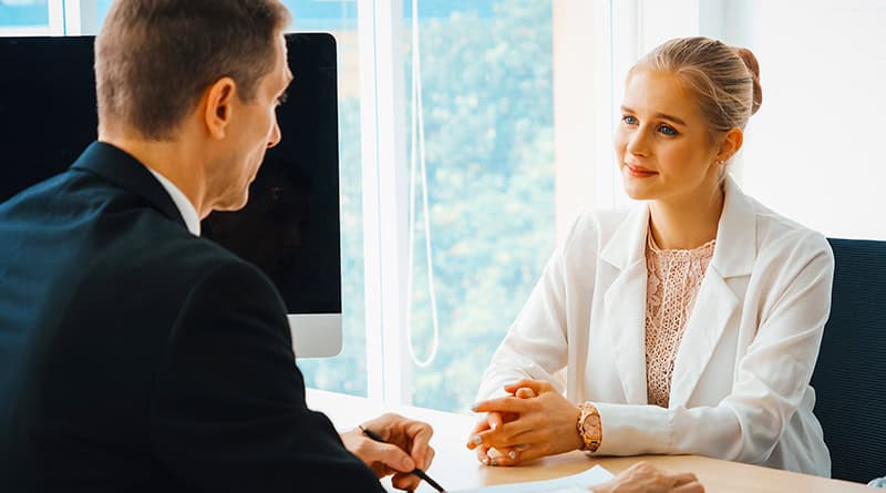 une femme reçu par un homme pour son entretien professionnel devant un bureau