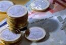 Billets et piles de pieces euros sur une table