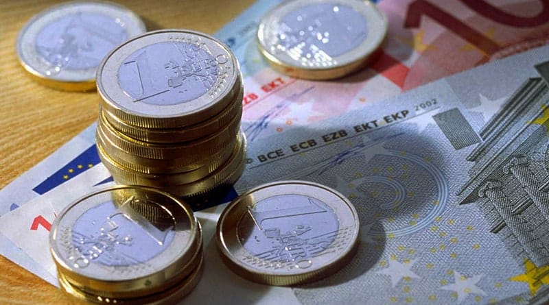 Billets et piles de pieces euros sur une table