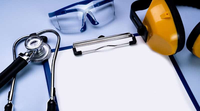 Sur un fond bleu ciel, un stéthoscope, des lunettes de protection, un casque anti bruit et un bloc papier