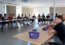 Des jeunes femmes et hommes autour d'une table en U en réunion